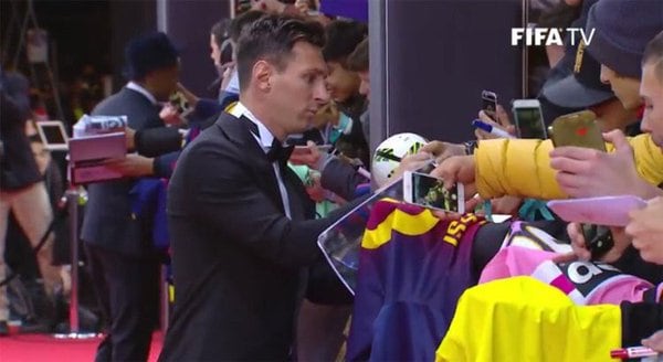 Lionel Messi, firmando autógrafos al llegar. 