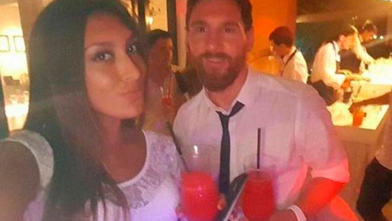 Lionel Messi posando junto a una morocha en la fiesta.