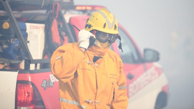 Los bomberos combaten el incendio a metros de la autopista. Foto: Lucio Casalla / El Doce