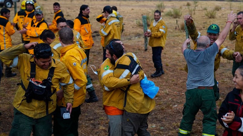 Los bomberos que estaban en la línea de fuego festejaron la llegada de la lluvia.