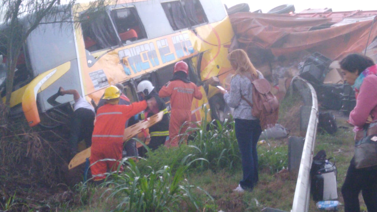 Los bomberos trabajan en el rescate de los pasajeros atrapados en el colectivo de Crucero del Norte.