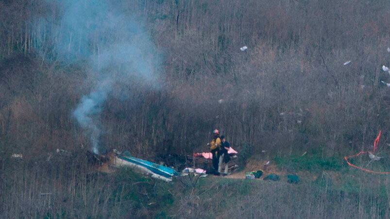 Los bomberos trabajando en el lugar donde se cayó el helicóptero.