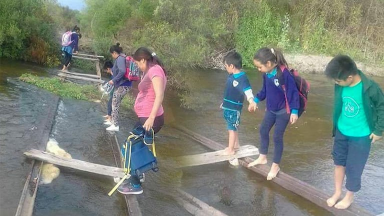 Los chicos cruzan el río como pueden para llegar a la escuela. 