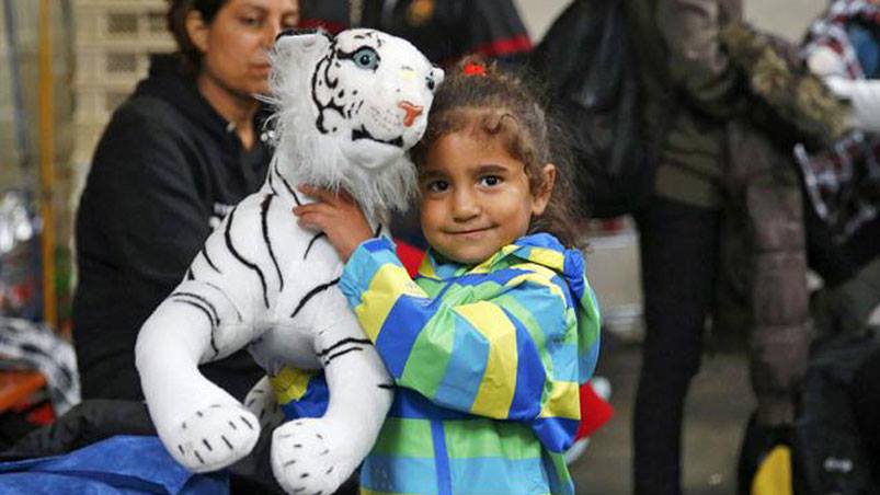 Los chicos juegan con los peluches que le regalan los ciudadanos alemanes. Foto: Reuters