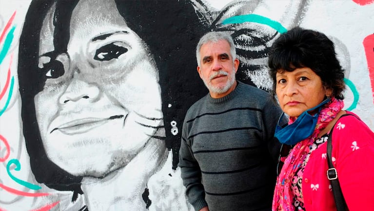 Los padres de Cecilia Basaldúa junto a un mural de su hija.