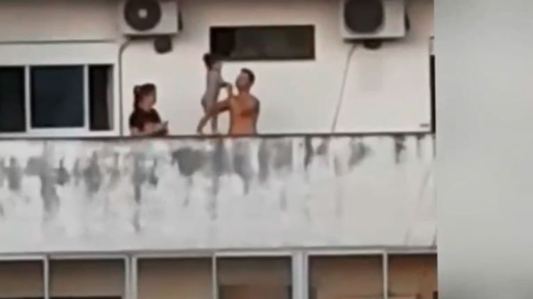Los padres hacen caminar por el borde de un balcón a su hija.