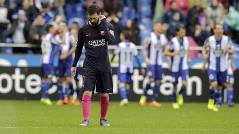 Messi con la cabeza gacha, mientras sus rivales celebran.