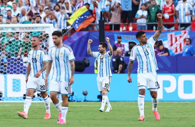 Messi festejando su primer gol ante Argelia y, de fondo, la bandera de "Los Pibes del Alambrado", una agrupación de hinchas de Instituto. REUTERS/Bernadett Szabo