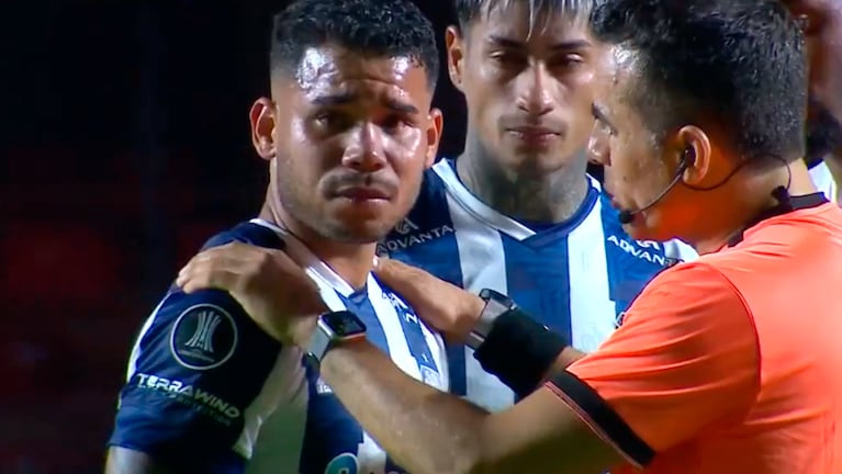 Miguel Navarro al ser contenido por el árbitro Piero Maza.