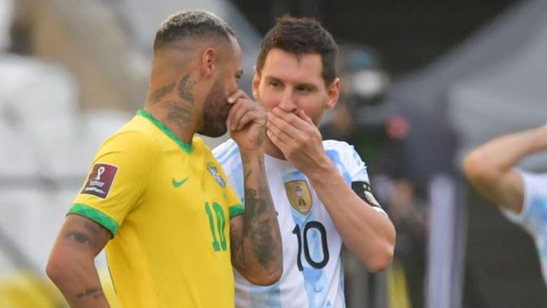 Neymar Jr y Messi hablando en el campo de juego.
