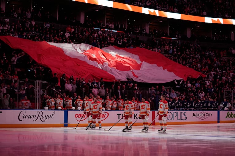 Oct 28, 2025; Toronto, Ontario, CAN; Calgary Flames stand during the anthem before a game against the Toronto Maple Leafs at Scotiabank Arena. Mandatory Credit: John E. Sokolowski-Imagn Images