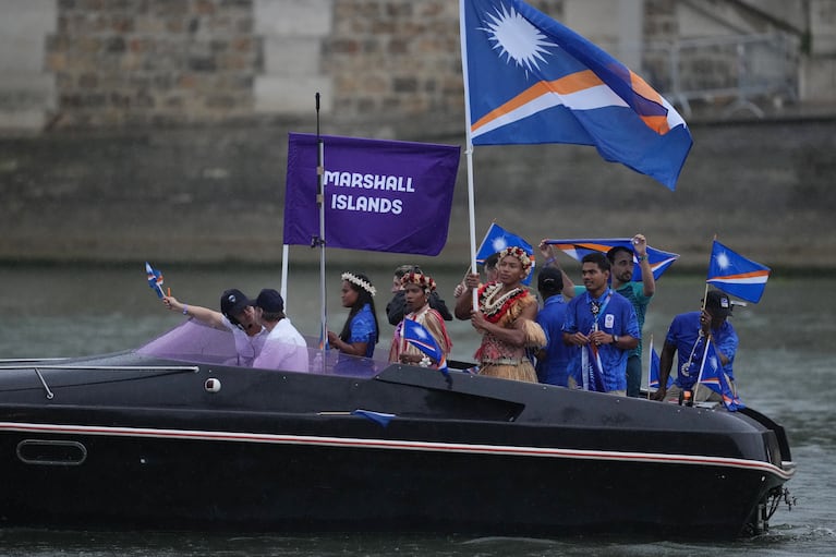 Paris 2024 Olympics - Opening Ceremony - Paris, France - July 26, 2024. Athletes of Marshall Islands aboard a boat in the floating parade on the river Seine during the opening ceremony. REUTERS/Aleksandra Szmigiel