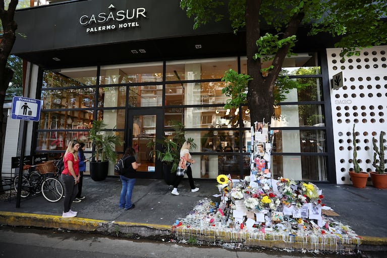 People stand next to tributes left outside the hotel where Liam Payne, former One Direction band member, was found dead after he fell from a third-floor hotel room balcony, in Buenos Aires, Argentina, October 18, 2024. REUTERS/Agustin Marcarian     TPX IMAGES OF THE DAY