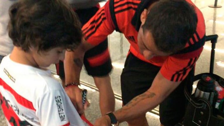 Recién bajado del avión, Rodrigo Mora le firmó la camiseta a un niño en el Aeropuerto.