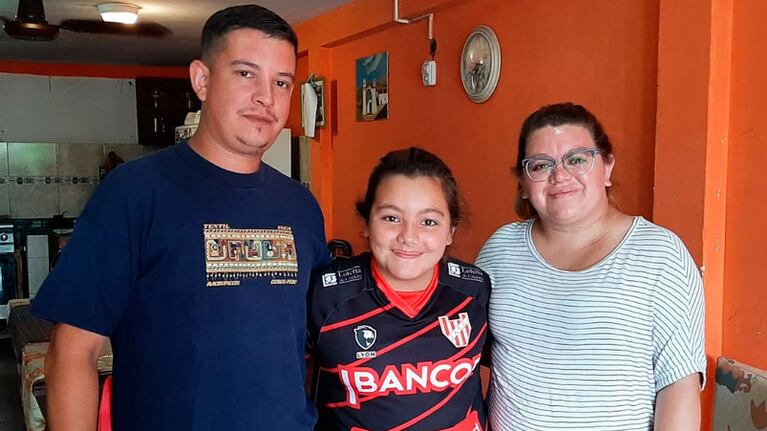 Renata con la camiseta de Instituto abrazada a su mamá y papá. Foto: Francisco Arias/El Doce.