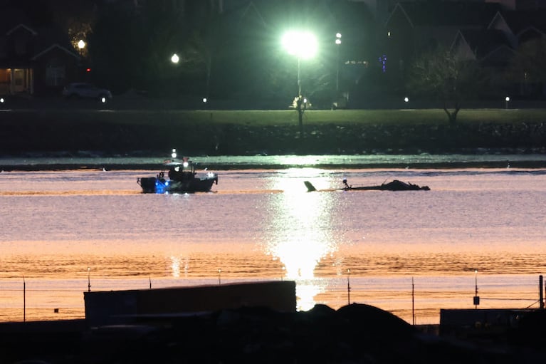 Rescuers on a boat work, as the sun rises, at the site of the crash after a Black Hawk helicopter collided with the American Eagle flight 5342, which was approaching Reagan Washington National Airport, and crashed into the Potomac River, outside Washington, U.S., January 30, 2025. REUTERS/Kevin Lamarque     TPX IMAGES OF THE DAY