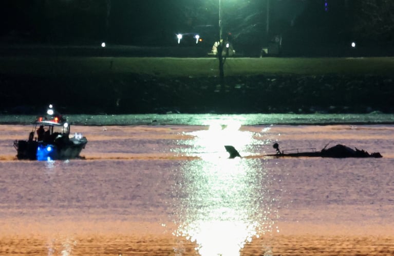 Rescuers on a boat work next to the wreckage of a Black Hawk helicopter at the site of the crash after it collided with the American Eagle flight 5342 which was approaching Reagan Washington National Airport and crashed into the Potomac River, outside Washington, U.S., January 30, 2025. REUTERS/Kevin Lamarque