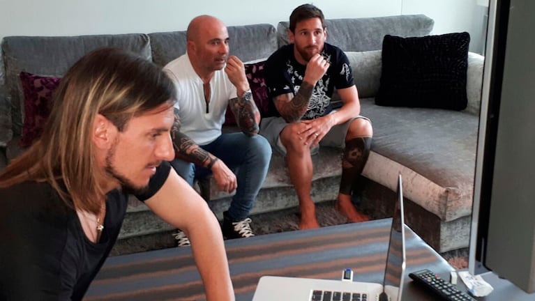 Sampaoli y Messi miran la pantalla mientras Beccasese maneja la computadora.