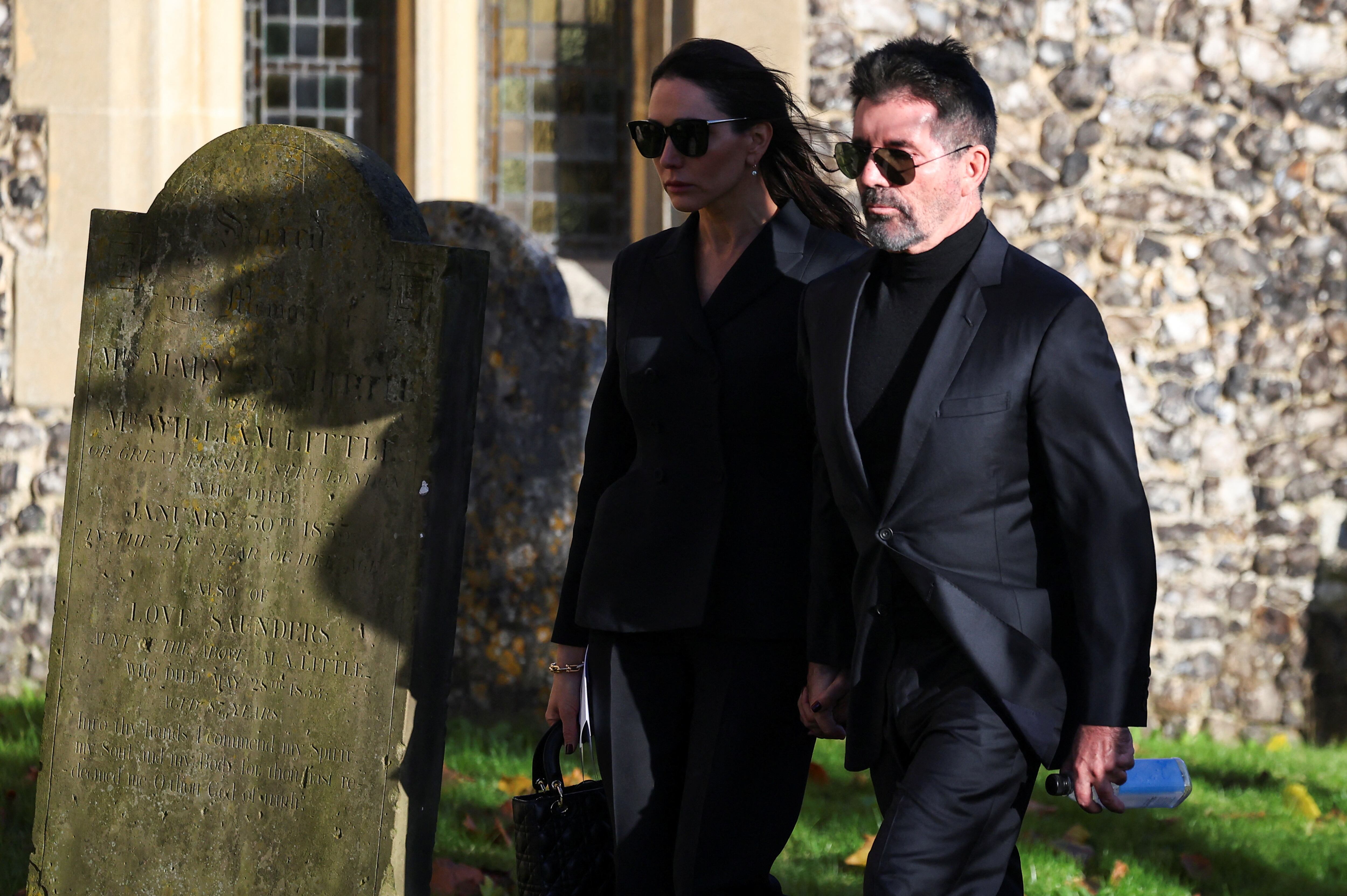 Simon Cowell and his wife Lauren Silverman walk on the day of the funeral of former One Direction singer Liam Payne at St. Mary's Church in Amersham, near London, Britain, November 20, 2024. REUTERS/Toby Melville