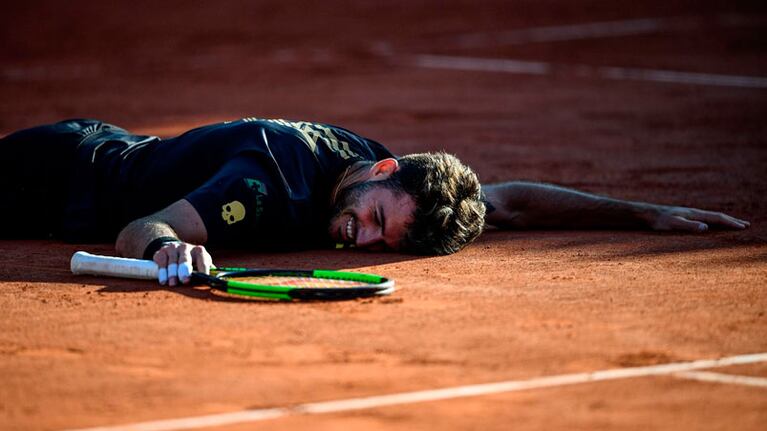 Tras un duelo extenuante, Londero festejó la victoria tirándose al polvo de ladrillo. Foto: AFP.
