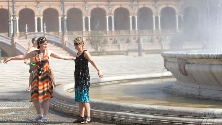 Turistas arrojando monedas a la fuente de la plaza de Sevilla. 