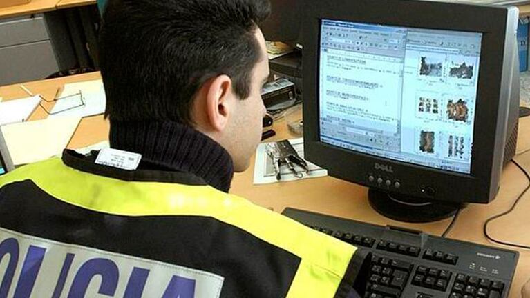 Un agente de la Policía Nacional examina la computadora del hombre detenido. Foto: Ideal.