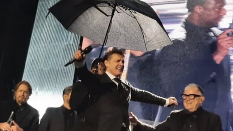 Un asistente le sostenía un paraguas a Luis Miguel durante su show en Córdoba.