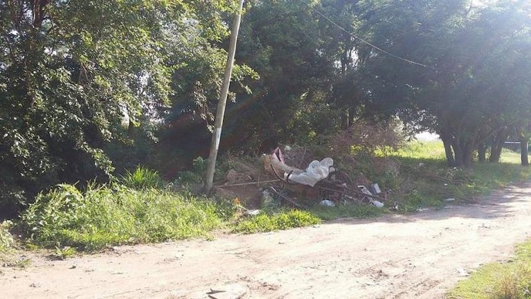 Un basural en medio de un barrio y un poste a punto de caerse