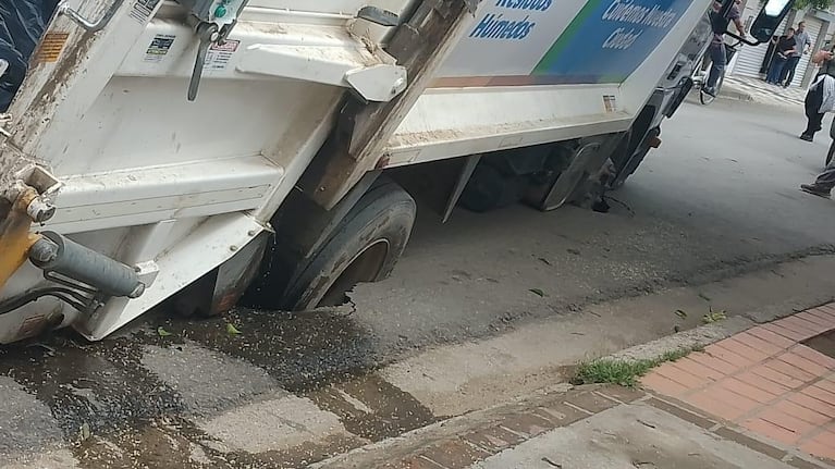 Un camión de basura se hundió y quedó colgado de costado: las fotos