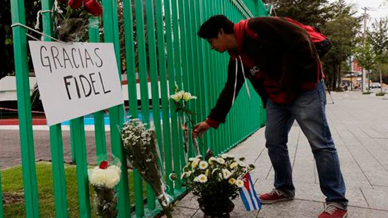 Un cubano deposita flores.