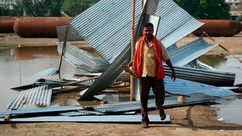 Un hombre junto a un cobertizo de chapa destruido cerca de una obra en construcción. Foto: AFP