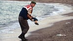  Un oficial de gendarmería lleva el cuerpo sin vida de un niño después de que el barco en el que viajaba. Foto: AP