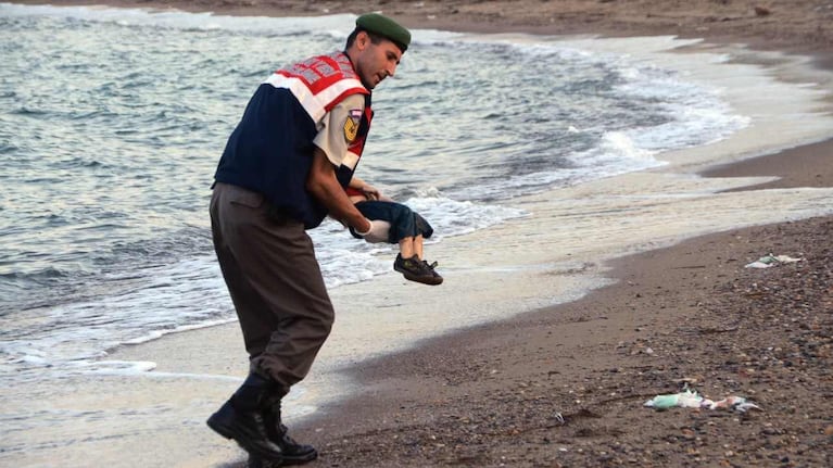  Un oficial de gendarmería lleva el cuerpo sin vida de un niño después de que el barco en el que viajaba. Foto: AP