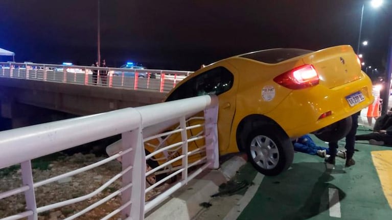 Un taxi quedó colgado de un puente al chocar contra una moto: tres heridos