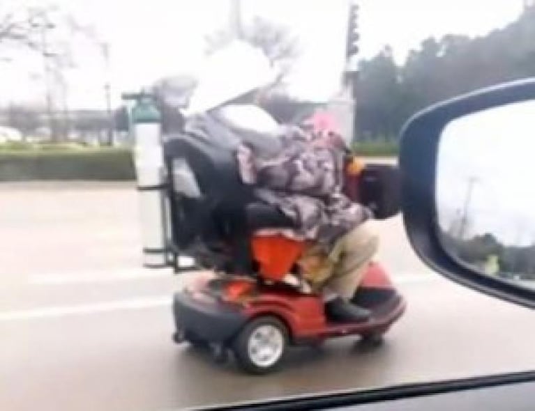 Una abuela en silla de ruedas motorizada por la autopista