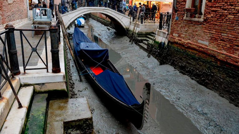 Una góndola encallada en el barro en un canal de Venecia. Foto: AFP