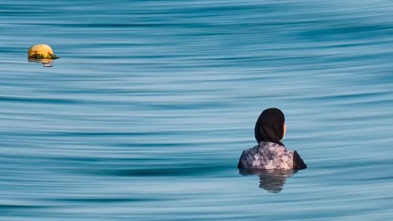 Una mujer musulmana metida en el mar con sus vestimentas. Foto: Lucio Casalla/El Doce.
