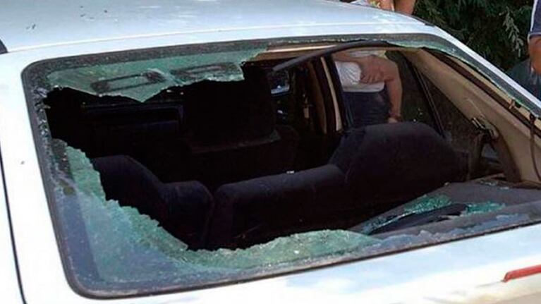 Uno de los autos rotos con una piedra.