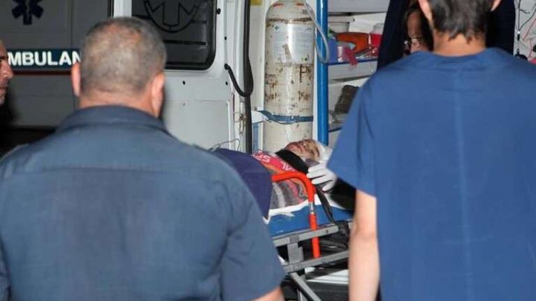 Uno de los heridos de gravedad es subido a la ambulancia.
