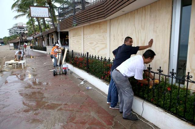 Varias casas protegidas con maderas, machimbres y bolsas de arena