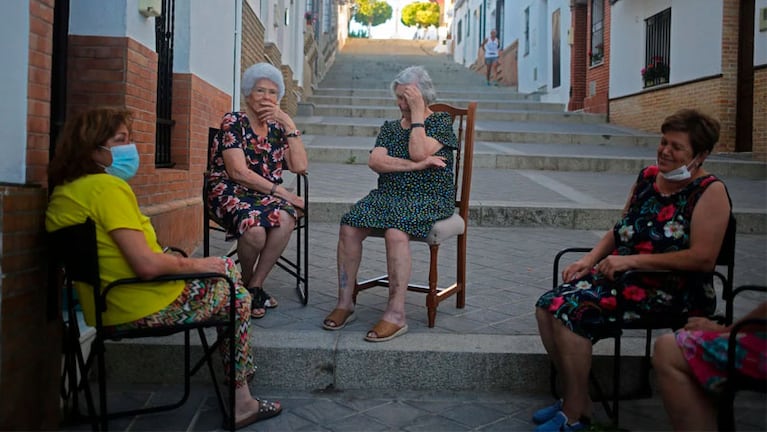 Vecinas del pequeño pueblo disfrutan del verano en una de las calles típicas del lugar.