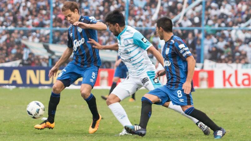 Velázquez intenta entre dos futbolistas del Decano. 