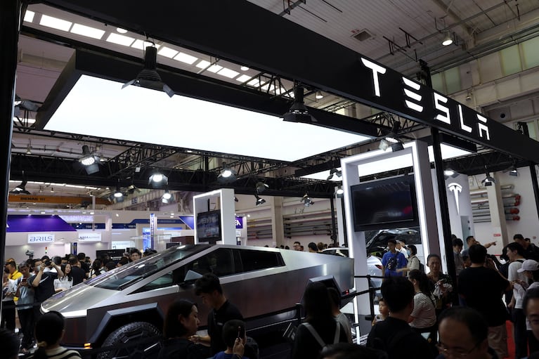 Visitors walk past Tesla's Cybertruck displayed at the World Robot Conference in Beijing, China August 21, 2024. REUTERS/Florence Lo